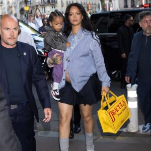 Rihanna with baby in one hand, pregnant and in heels